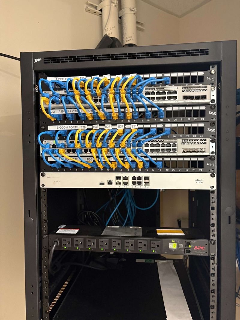 Completed business network rack with labeled patch panels, network switches and organized patch cabling